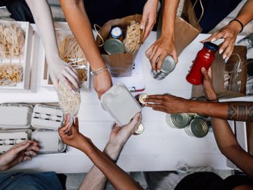 People sorting and packing food items on a table.
