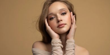 Young woman posing with hands on face.
