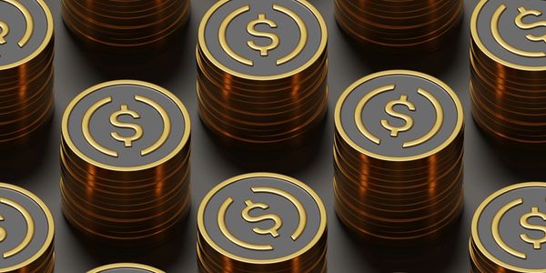 Stacks of gold coins with dollar signs on a dark background.