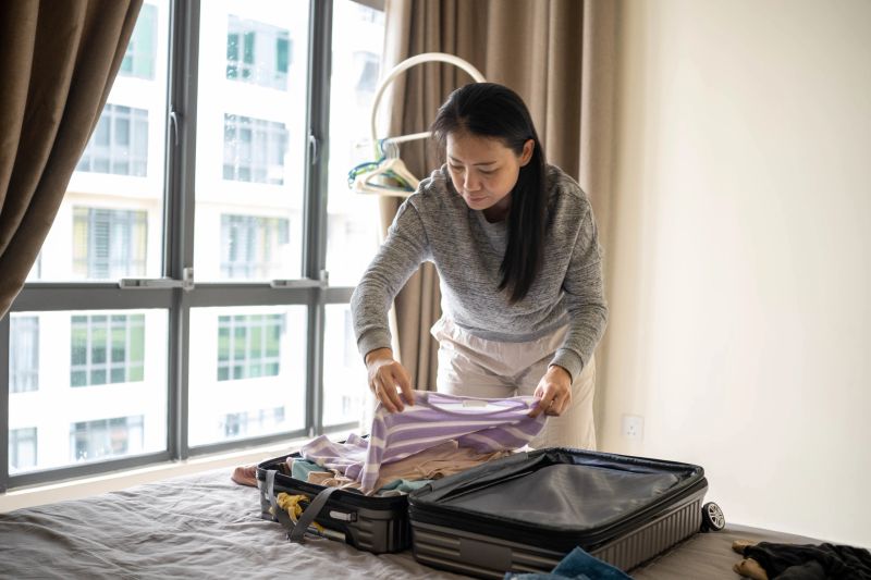 Female traveler organizing and packing belongings before heading out of the hotel.