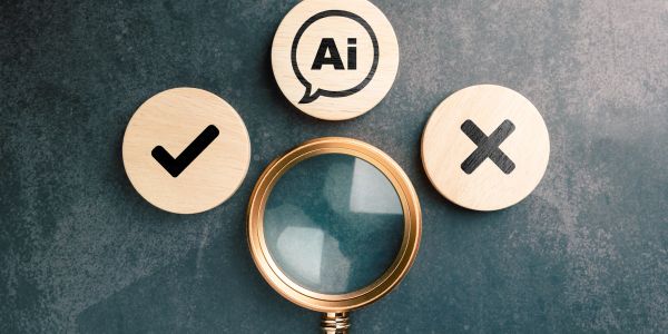 Magnifying glass with wooden tokens showing AI, checkmark, and cross symbols.