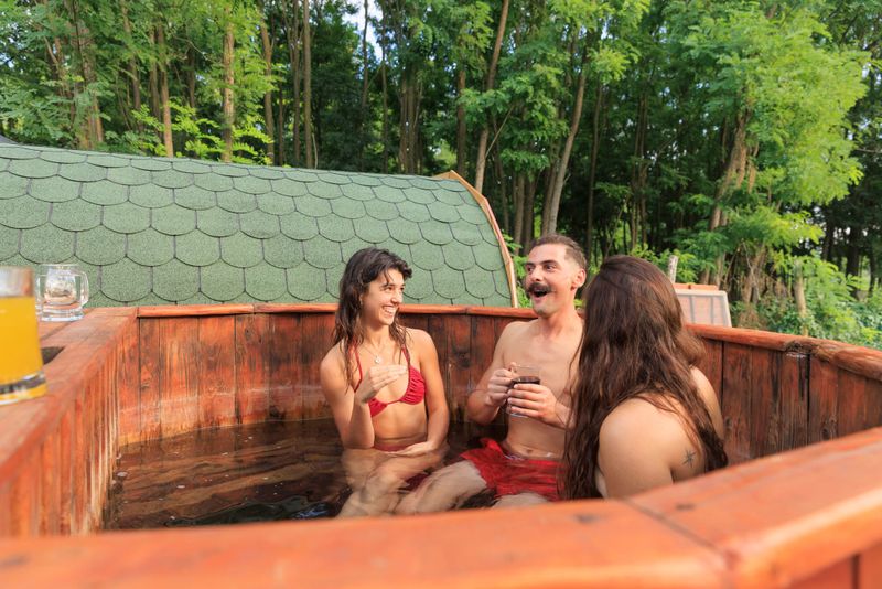 Relaxation Spa Treatment  Two Young woman and handsome man in  outdoor hot tub,  wooden  bath barrel swimming pool,  Beautiful couple in love. Wellbeing Relaxing and enjoying  health spa life balance,    Eco tourism, weekend activities.