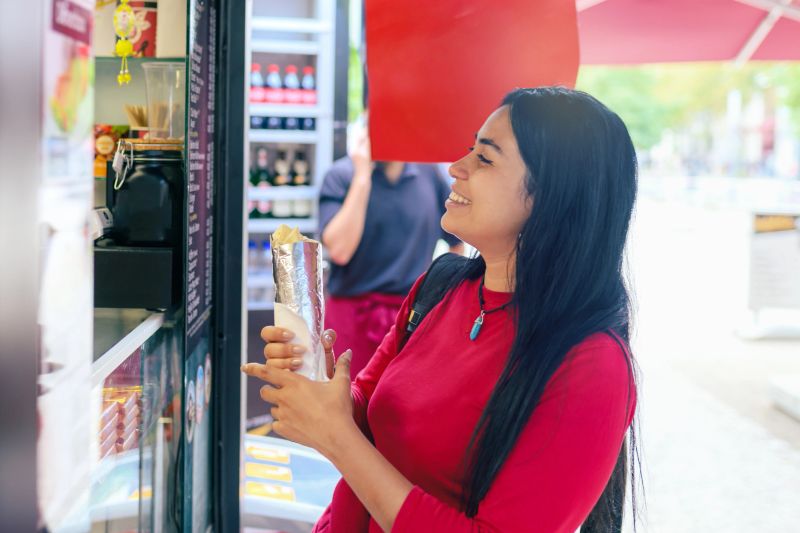 young woman holding dürüm at food stall on street in berlin city