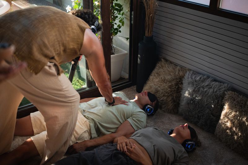 Breathwork practitioner guiding people lying on the floor in conscious connected breathing session