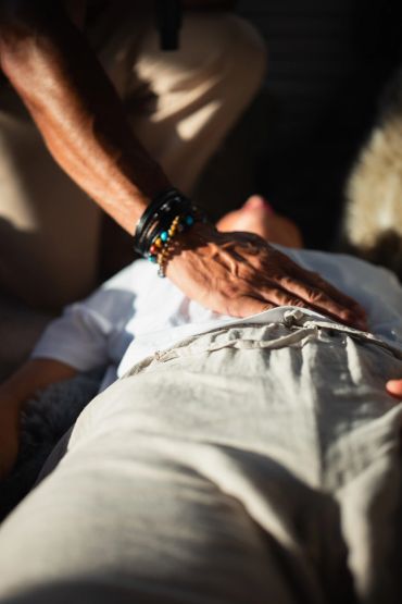 Person touching another person's stomach gently.