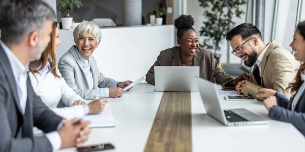 A diverse group laughing during a business meeting.