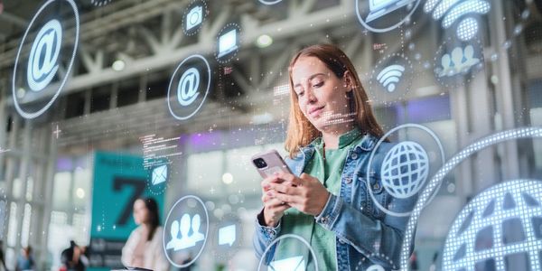 Woman using smartphone with digital communication icons.