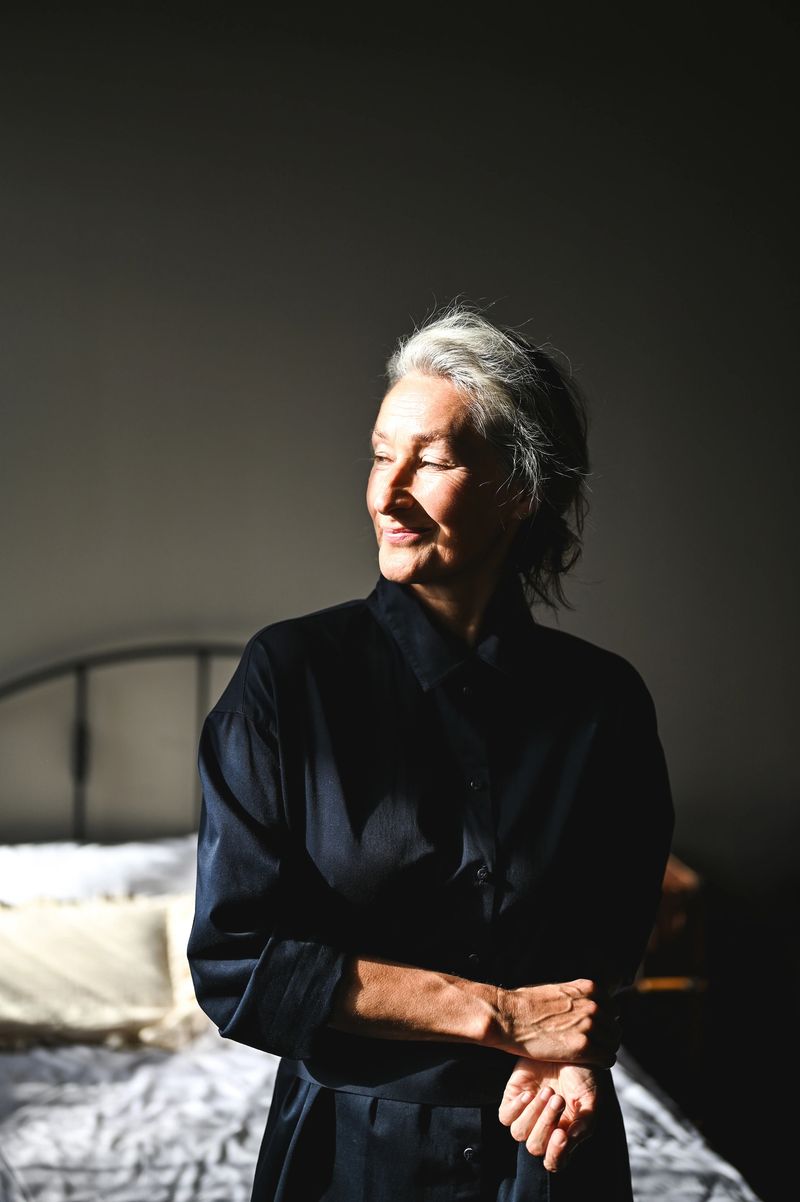 Portrait of a stylish senior woman relaxing in her bedroom, enjoying the warm sunlight