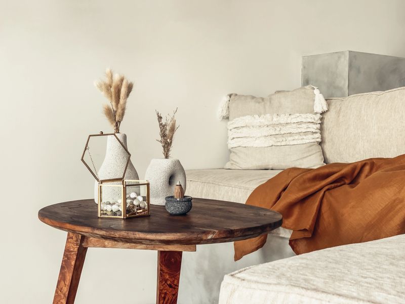 Decorative lava stone vases with dry flowers, jewelry box and incense stick on the coffee table in the living room near sofa