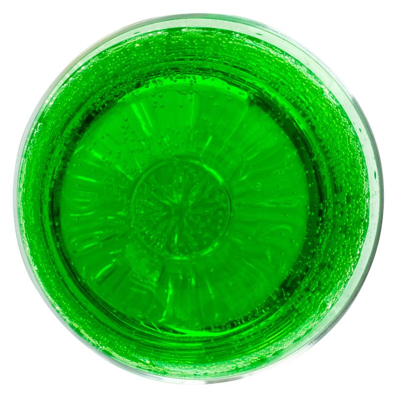 Top View of Green Drink in Glass on White Background.
