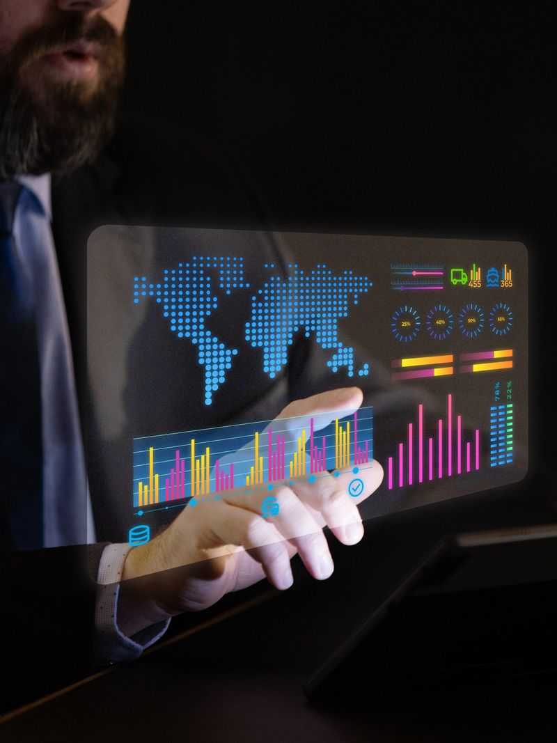 Male hand interacts with futuristic transparent interface showing global charts, logistics stats, and bar graphs in digital business environment. Concept of trade analytics tools