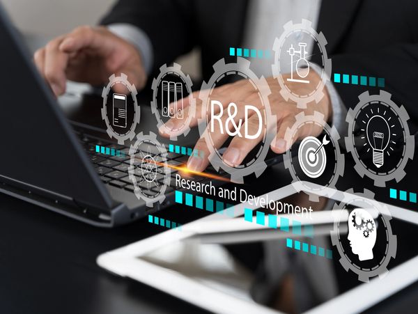 Person working on a laptop with R&amp;D and innovation icons overlay.