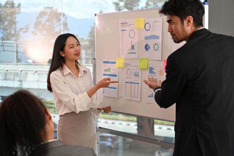 Business professionals presenting financial charts and data during a meeting, discussing key insights and strategies.