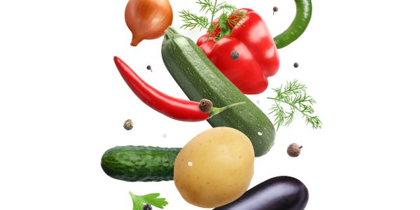 Various fresh vegetables including pepper, zucchini, and potato against white background.
