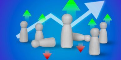 Wooden figurines with upward and downward arrows representing team dynamics.
