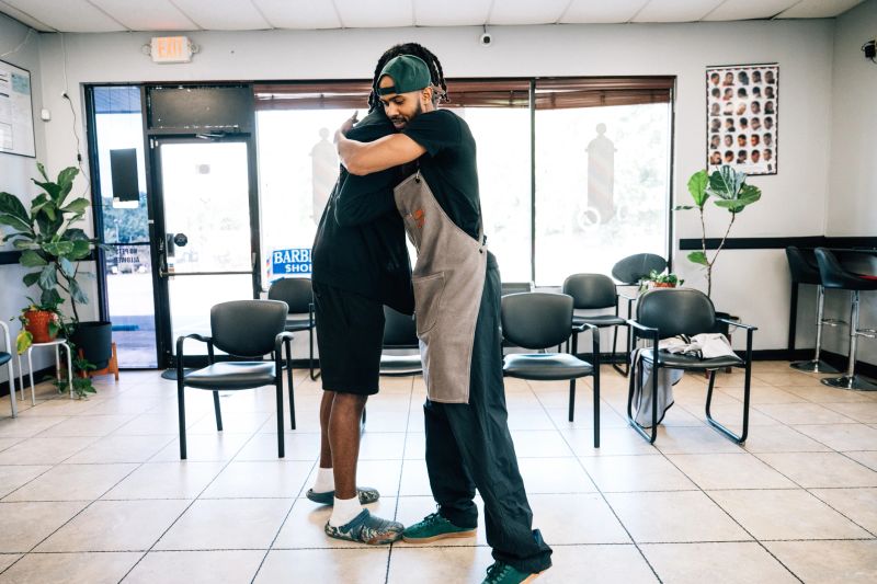 Barber greeting a returning client with a hug
