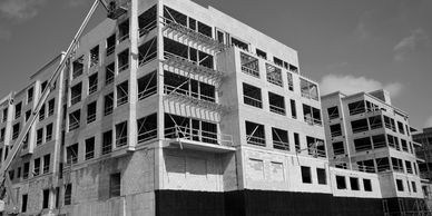 Large building under construction in black and white.