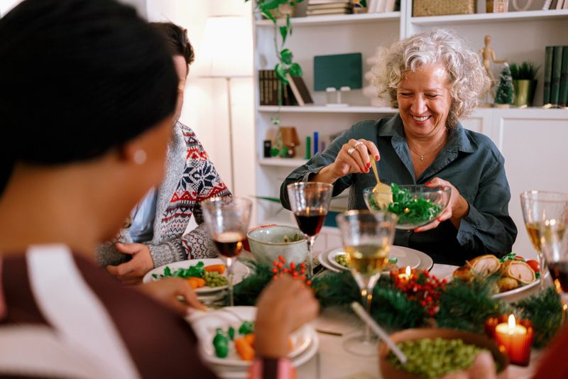 Diverse family celebrating Christmas together, with a table full of traditional holiday dishes.