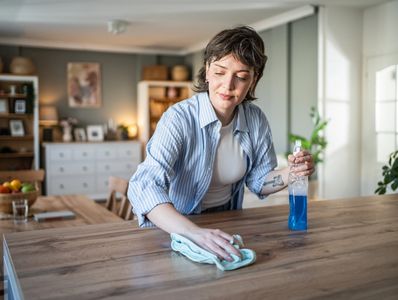 Woman wiping a wooden table