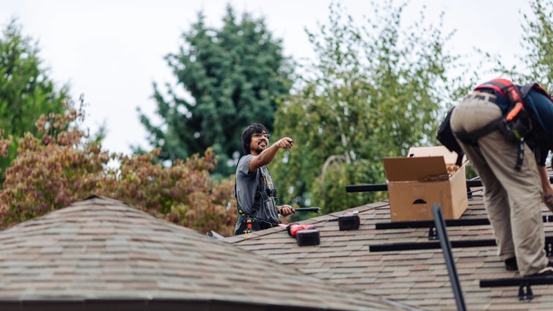 Professional engineers installing solar panels on roof of a residential home in Portland, Oregon, Pacific Northwest USA. Green energy concepts. Real installation crew using real safety equipment.