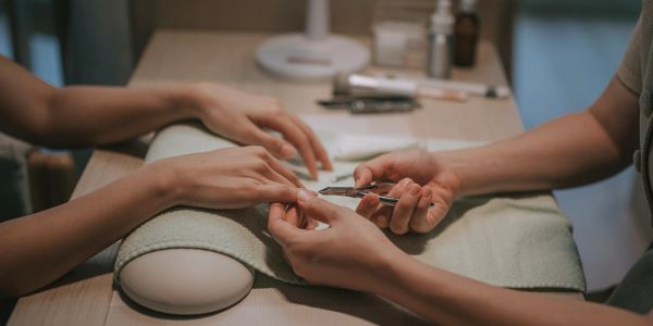 Person getting a manicure with nail clippers.