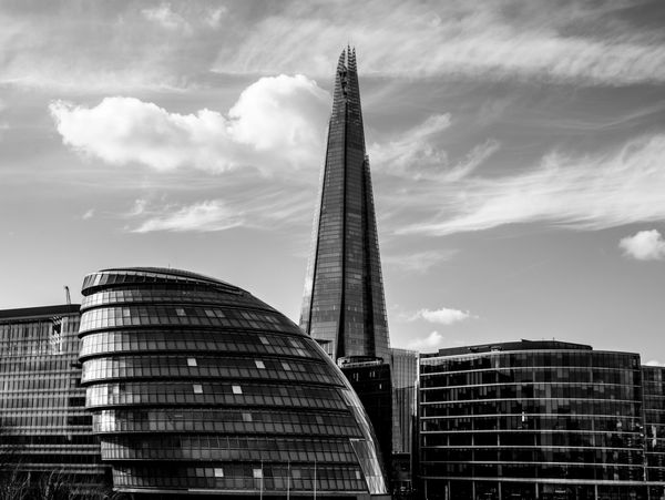 Black and white photo of modern skyscrapers with a dramatic sky.