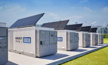 Energy storage units with solar panels and wind turbines in a clean energy setup.