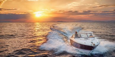Boat cruising on water at sunset.