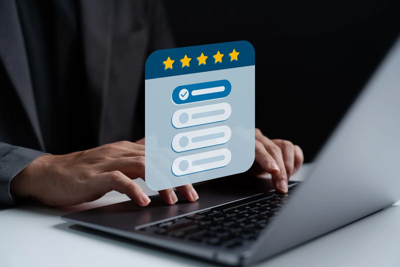 Customer feedback and rating system concept. Business person using laptop to fill out digital survey with five-star ranking and multiple choice form, illustrating satisfaction evaluation process.