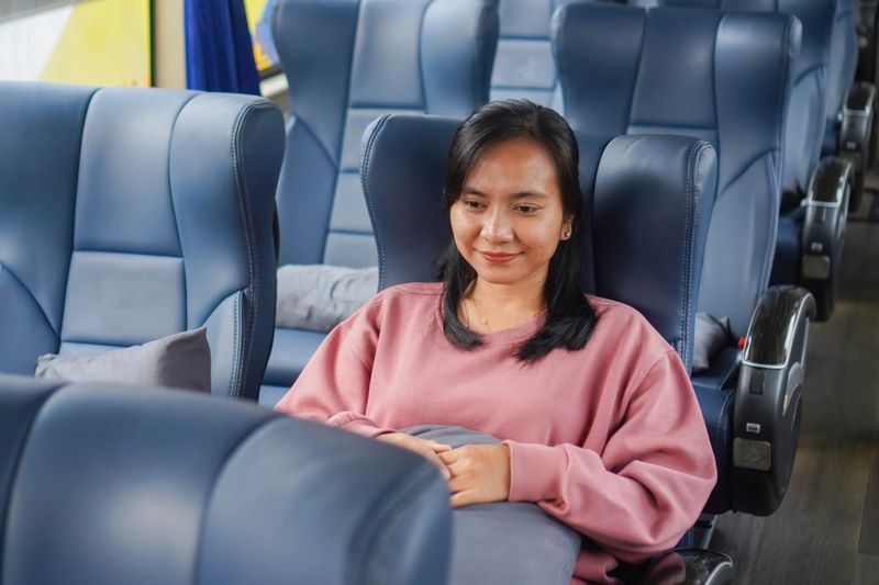 Female passenger sitting comfortably in modern bus interior.