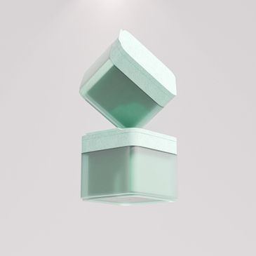 Two pastel green square containers with lids, one floating above the other.