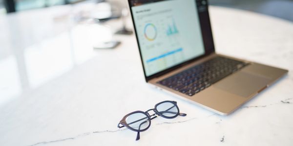 Lentes con una laptop que indican la experiencia y el foco en los detalles