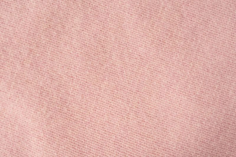 Soft pink cashmere sweater texture background. Top view.