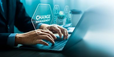 Person typing on laptop with change management icons.