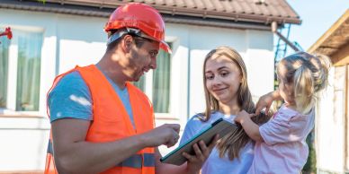 Construction worker consulting with woman holding a child.
