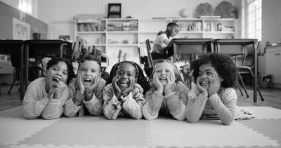 Five children lying on the floor smiling.