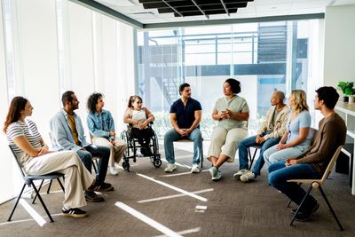 People with disabilities and friends enjoying outdoor art and socializing at a community event.