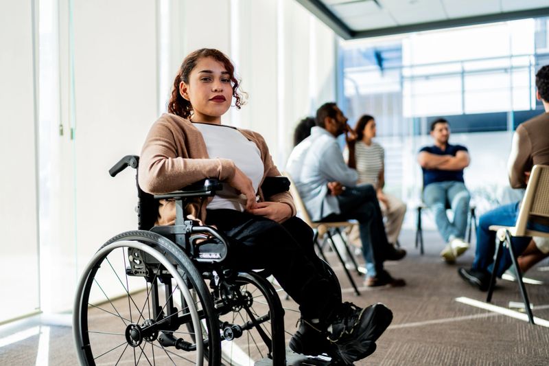 Portrait of young wheelchair woman during group therapy session