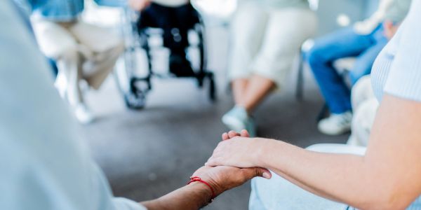 Persone che si tengono per mano in cerchio.