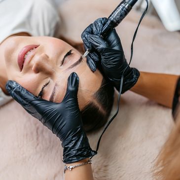 Woman getting eyebrow tattooing.