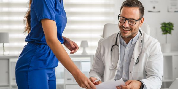 Doctor and nurse reviewing medical documents together in an office.