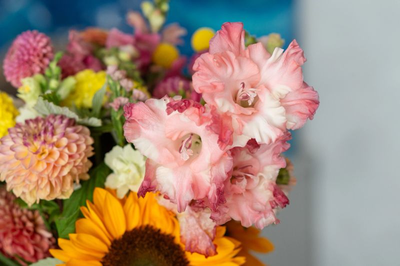 Colorful floral bouquet with gladiolus, dahlias, and sunflower in vibrant display.