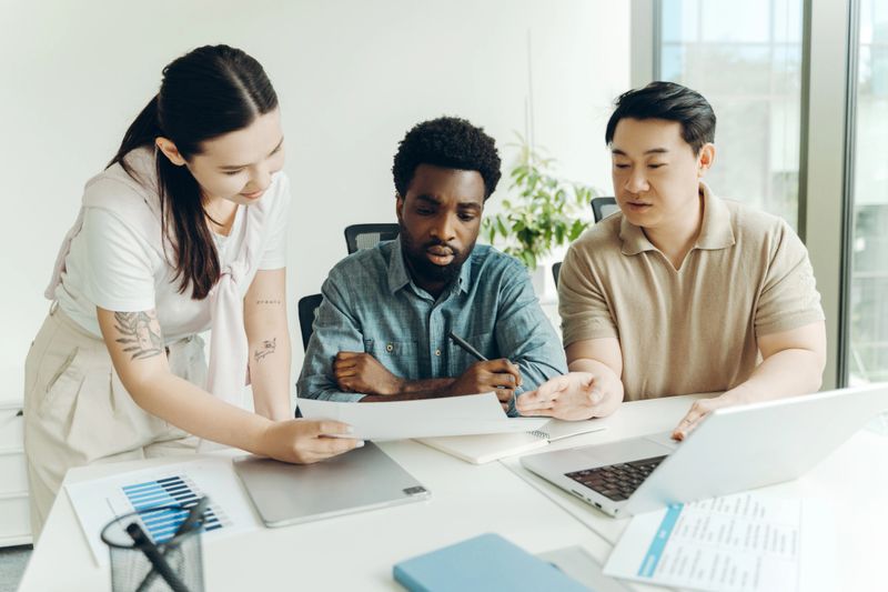 Diverse group of multinational business team analyzing charts and reports in modern office. Business concept