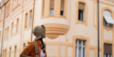 Woman looking at a building with an orange facade.
