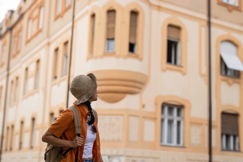 Young woman with backpack admiring architecture during her city trip