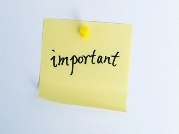 Yellow sticky note with the word 'important' pinned on a white surface.