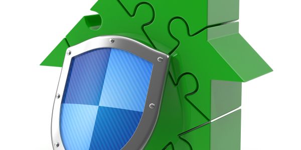 Green puzzle house with blue shield symbolizing home protection.