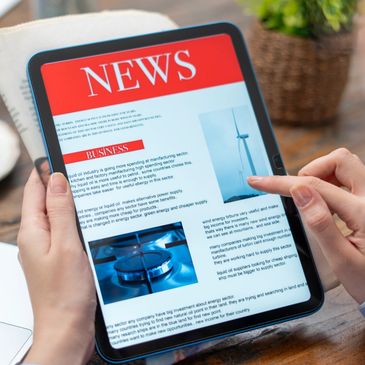 Person reading news on a digital tablet.
