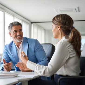 Two colleagues engaged in a discussion in a bright office.