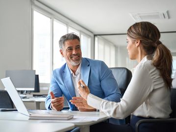 Dos personas conversando en una oficina.